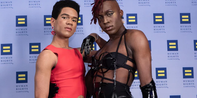 Two people in gala attire standing in front of a HRC branded step-and-repeat