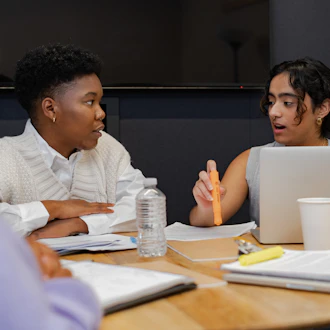 A trans person and a trans man discussing something in a meeting