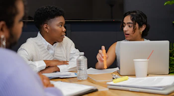 A trans person and a trans man discussing something in a meeting