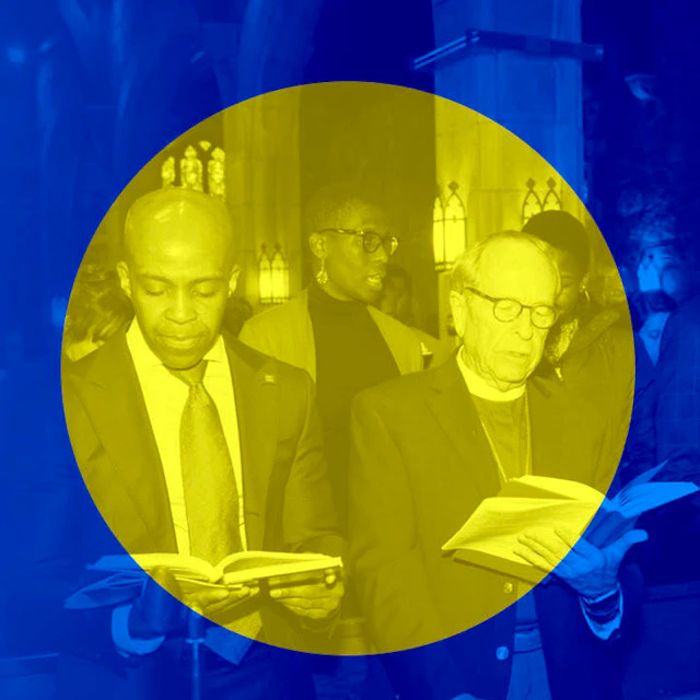 Alphonso David stands with a member of the clergy.