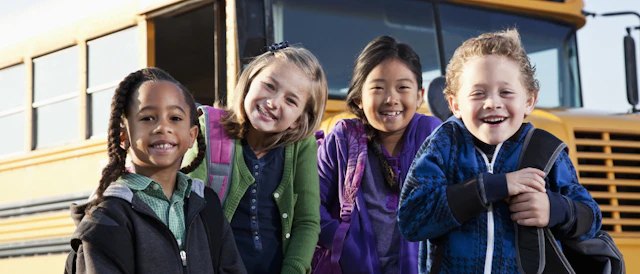 4 kids in front of a school bus 5 X3